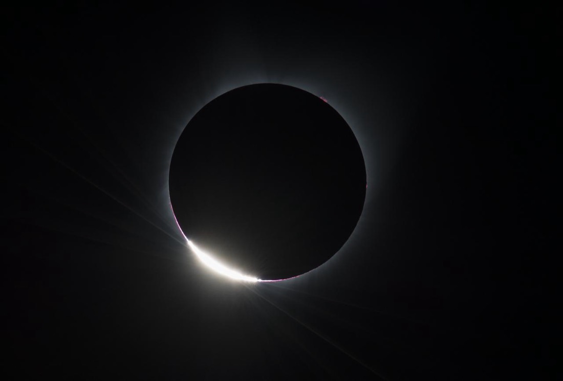 The “diamond ring” of a total solar eclipse: the Sun almost fully covered by the dark disc of the Moon, with one brilliant point of sunlight blazing at the edge.